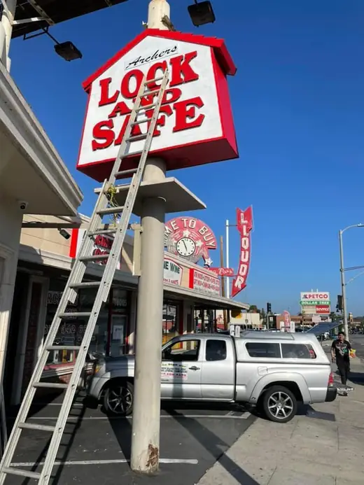Pole sign installation on a ladder